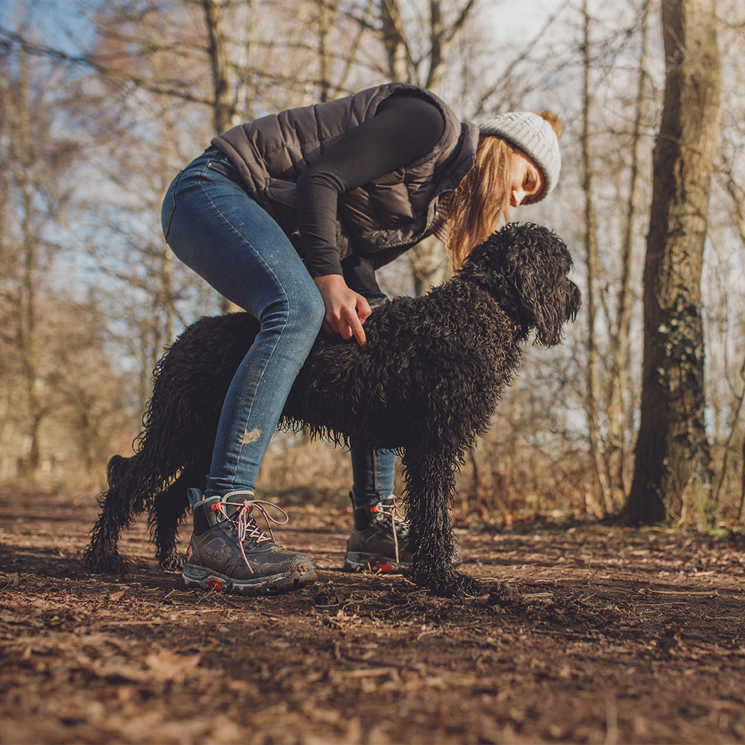 Woman holding a dog in an Autumnal wood