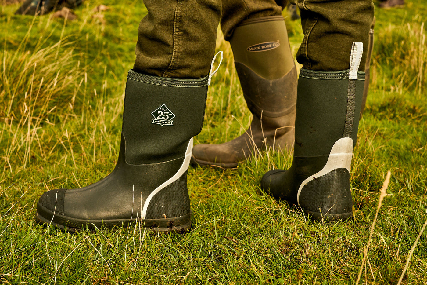 Close up image of a person wearing a pair of 25th anniversary Muck Boots wellingtons