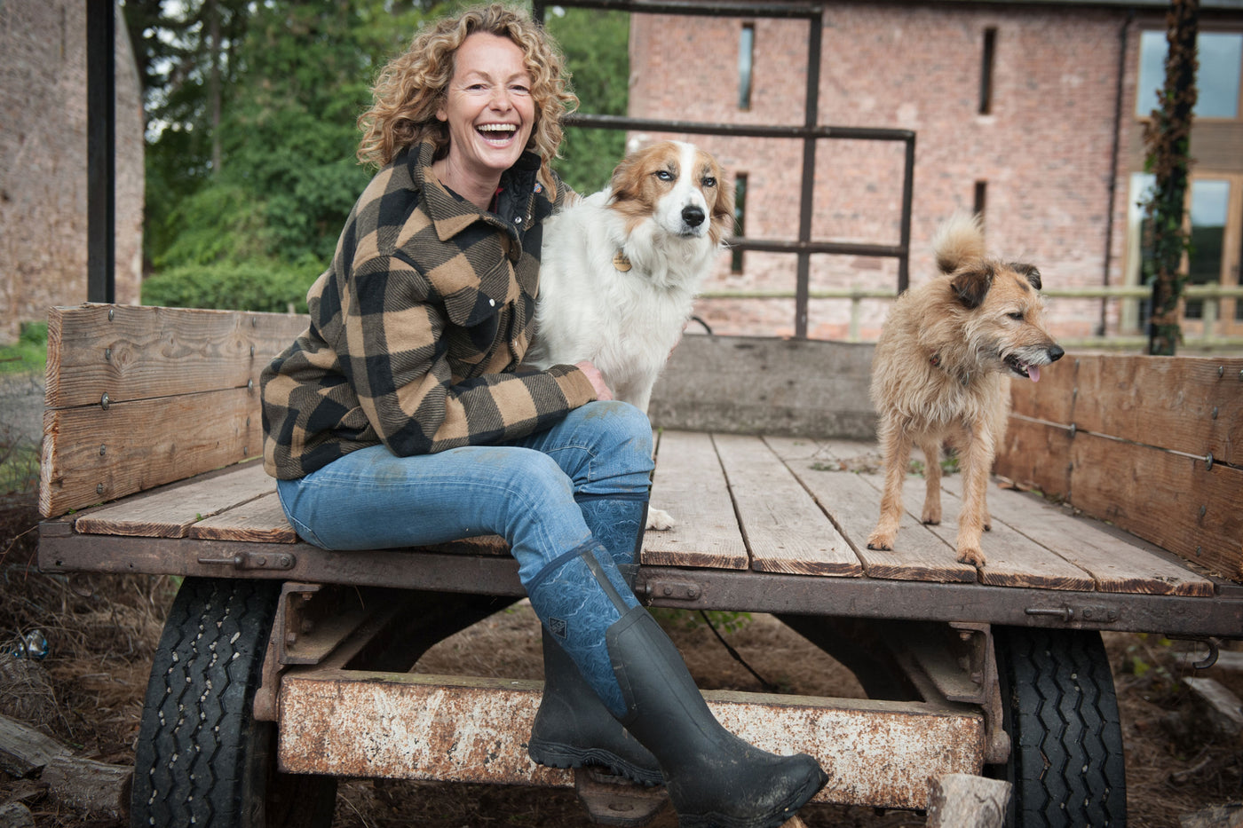 Kate Humble sat on a trailer with two dogs