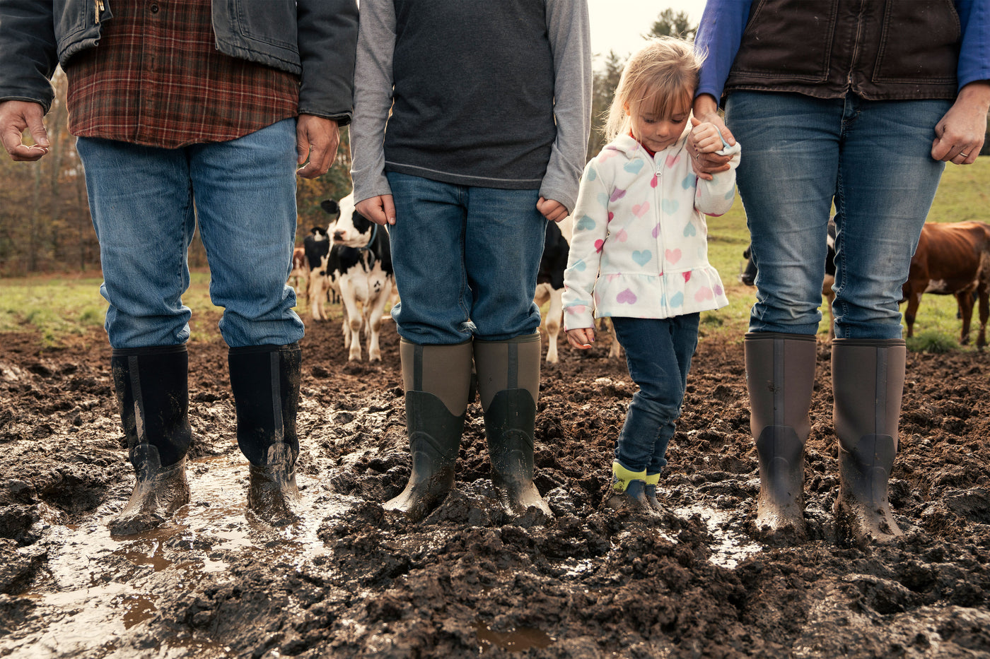 A group of people wearing Muck Boots in mud