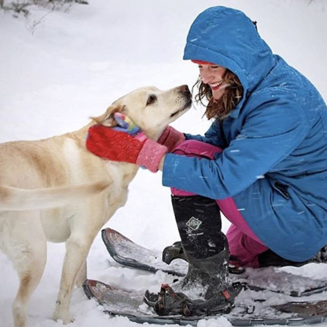 Woman playing with her dog in the snow