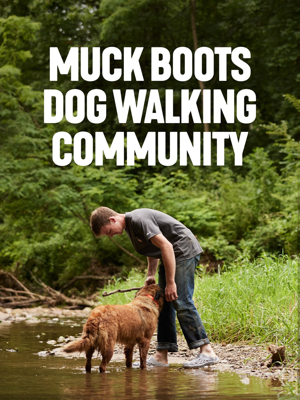 Boy wearing a pair of Muck Boots Muckster Clogs, playing with a dog in a stream. Text reads 'Muck Boot's Dog Walking Community'