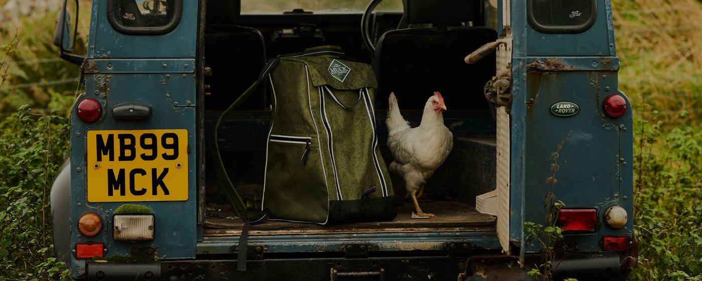 A Muck Boots back pack and a chicken in the back of a Land Rover 