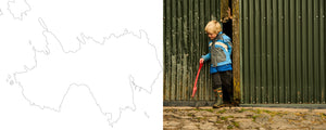 A map of the Isle of Muck on a white background on the left and a young boy wearing a blue jacket and pair of Muck Boot wellingtons, holding a red spade and walking through a gap between two green corrugated structures on the right