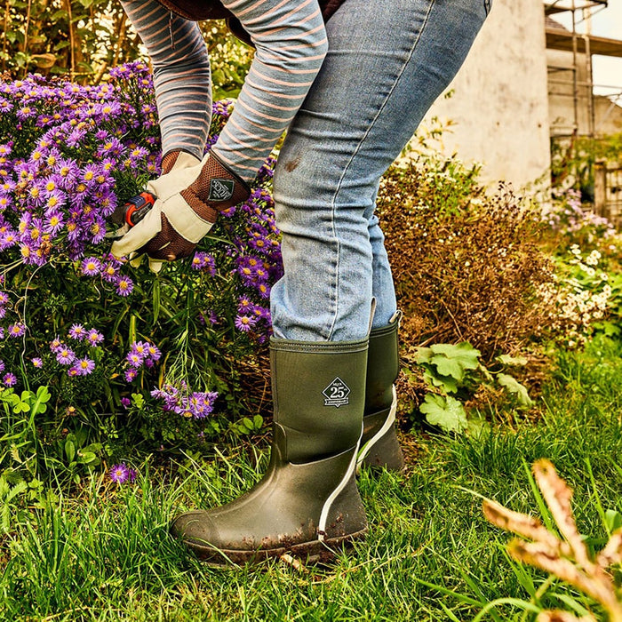 Person outside gardening while wearing Muck Boots gloves and wellingtons