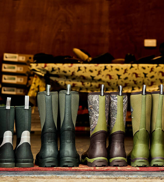 The backs of four pairs of Muck Boots Wellingtons inside a shed doorway