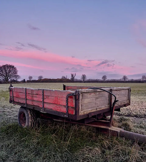 Trailer in a field with a pink sky